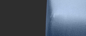 corner of a mattress showing a perfectly fitting jersey fitted sheet in sky blue. The surface is wrinkle-free and smooth
