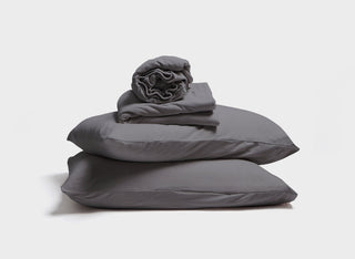 It-Fits jersey sheet set displayed as a stack of fitted sheet, flat sheet and a pillow with pillowcase in charcoal grey colour