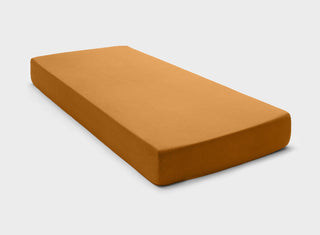 It-Fits jersey fitted sheet in ginger brown color, securely hugging a standard Australian mattress with deep pockets against a plain background.