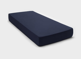 Temperature-regulating fitted sheet in Navy Blue colour by It-Fits, snugly covering a mattress with deep pockets against a plain background.