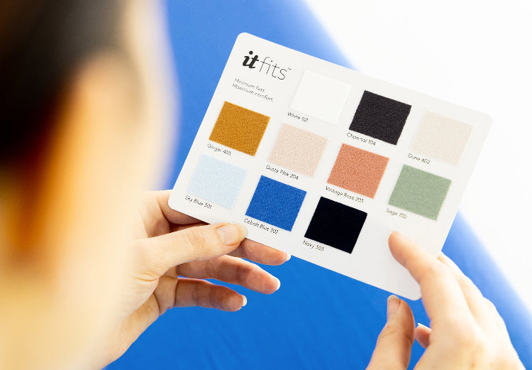 two hands holding it-fits colour cards showing the different colours of the sheets up close on royal blue and white background