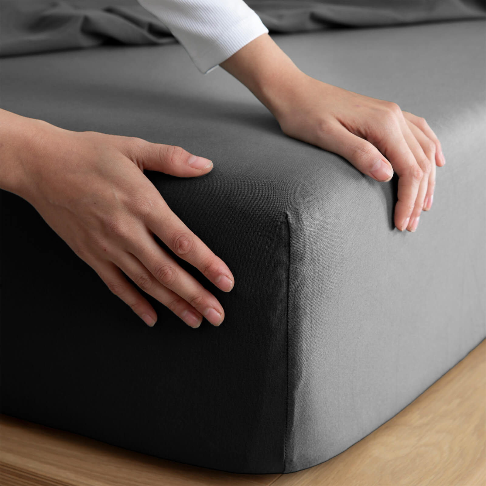 Close-up of fitted sheet stretching over mattress corner, showing secure fit and smooth finish without slipping