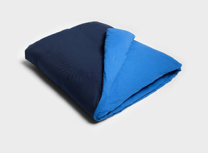 Navy and royal blue duotone quilt cover by It-Fits, displayed on a folded doona on plain background 